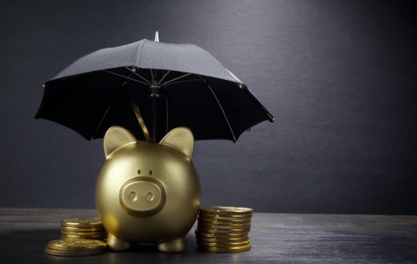 Gold Piggy bank with umbrella concept for finance insurance, protection, safe investment